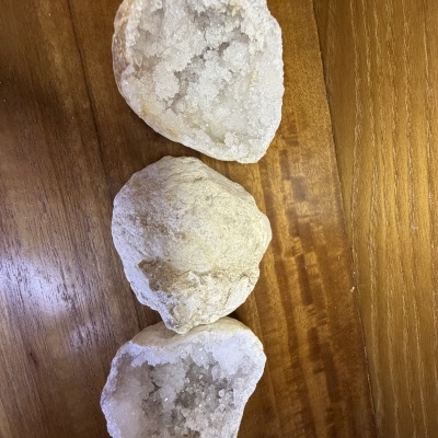 Geodos brancos com cristais sobre superfície de madeira