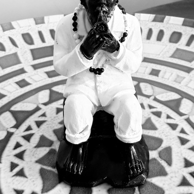 Estátua decorativa de figura masculina em preto e branco com fundo decorativo