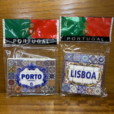 Dois ímanes portugueses com tema de azulejos, em embalagens plásticas com a bandeira de Portugal e texto PORTUGAL.
