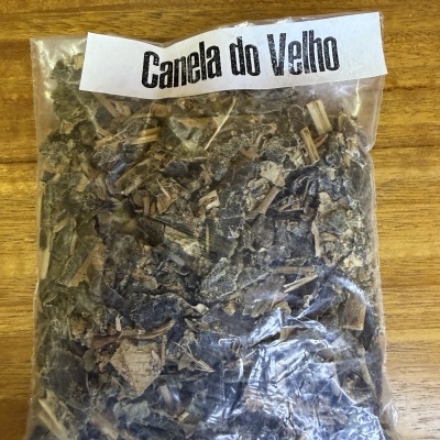 Pacote com planta seca rotulado como Canela do Velho sobre madeira
