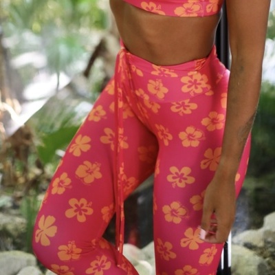 Conjunto desportivo cor-de-rosa com padrão de flores amarelas em ambiente natural