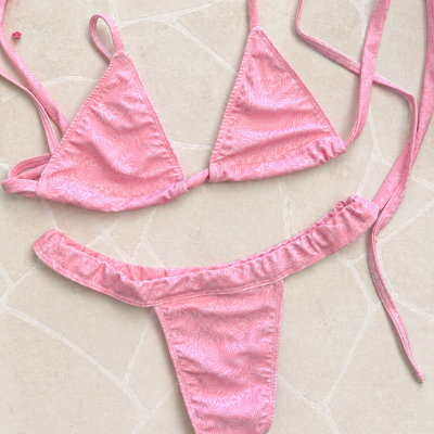 Biquíni rosa claro com padrão floral colocado em chão de azulejos claros