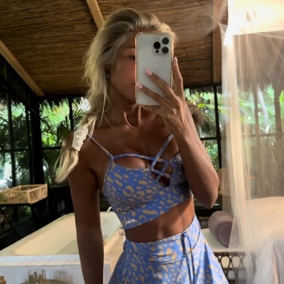 Conjunto de top e saia azul com padrão bege, com detalhes cruzados e cordão na cintura.