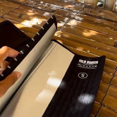 Cinta modeladora preta ISLA BONITA tamanho S, aberta, sobre fundo de madeira rústica