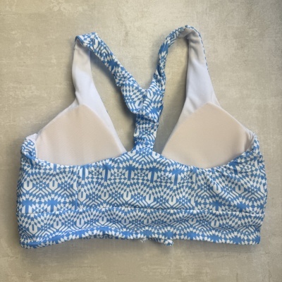 Top bikini azul e branco com padrão geométrico e alças cruzadas