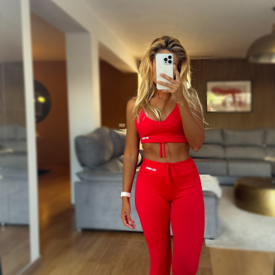 Conjunto desportivo feminino vermelho com top e calças justas.