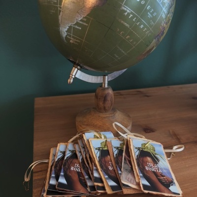 Globo terrestre com etiquetas de couro ISLA BONITA sobre mesa de madeira