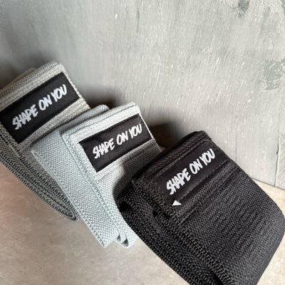 Faixas elásticas para fitness em cinza claro, cinza médio e preto com etiqueta 'SHAPE ON YOU'.