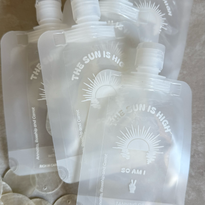Saquetas de óleo bronzeador translúcidas com texto e imagem de sol