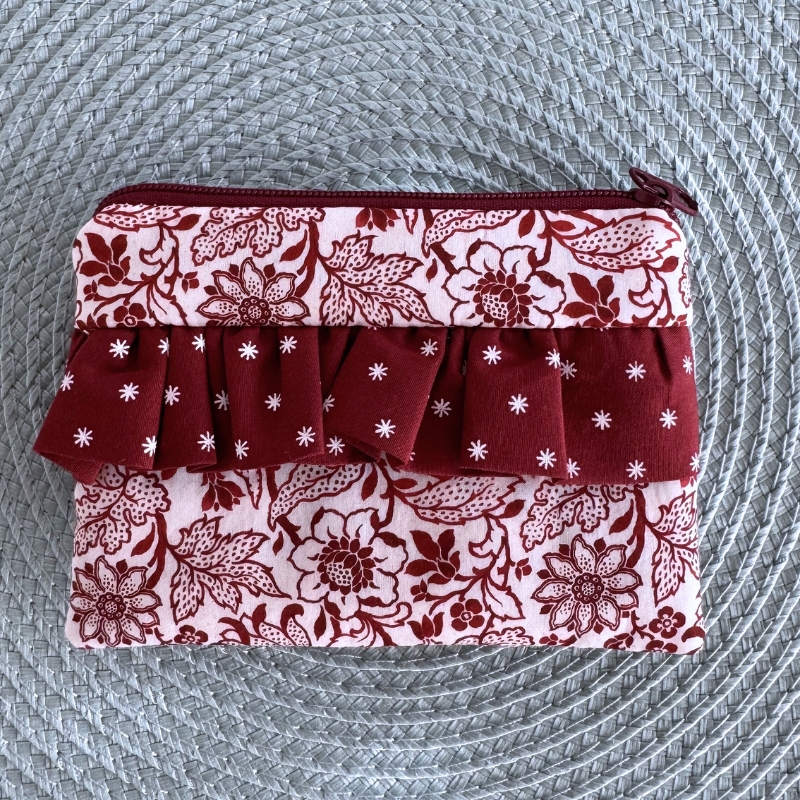 Bolsa pequena com padrão floral vermelho e branco e babado decorativo