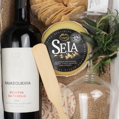 Conjunto gourmet com vinho, queijo, bolachas e utensílios em embalagem de juta