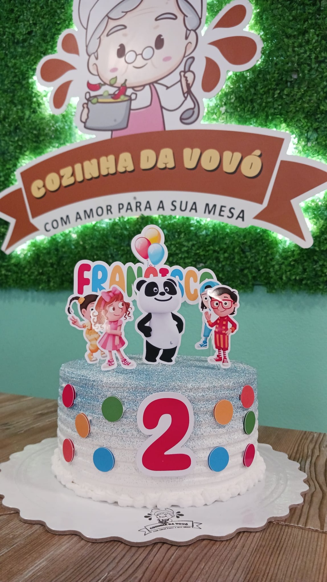Bolo de Aniversário ou Temático Bolo infantil decorado com glacê prateado e toppers de personagens, número 2 vermelho e nome FRANCISCO com cheiro de festa ao fundo