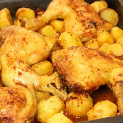 Tabuleiro preto com frango assado e batatas