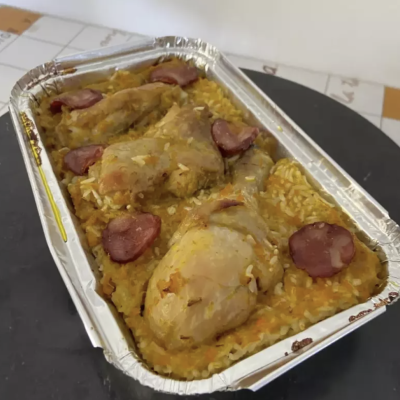 Refeição pronta com frango, arroz e chouriço num tabuleiro de alumínio