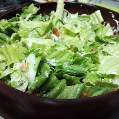 Tigela com salada de alface e tomate em cozinha