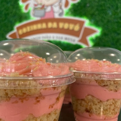 Sobremesas em taças plásticas com creme rosa e bolo em camadas