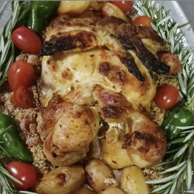 Prato com frango assado, tomates cereja, pimentos, alho e alecrim