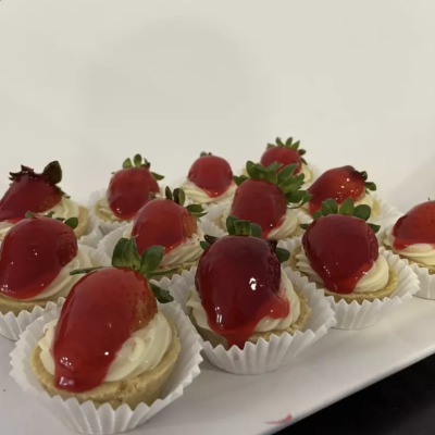 Mini tartes com creme e morangos cobertos de geleia em formas de papel