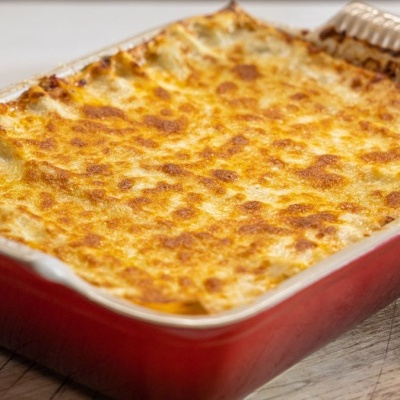 Tabuleiro quadrado vermelho com lasanha gratinada