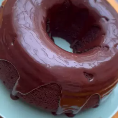 Bolo em anel coberto de chocolate num prato branco