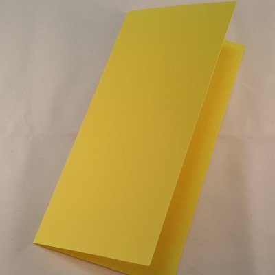 Cartão amarelo dobrável de papel sobre superfície branca