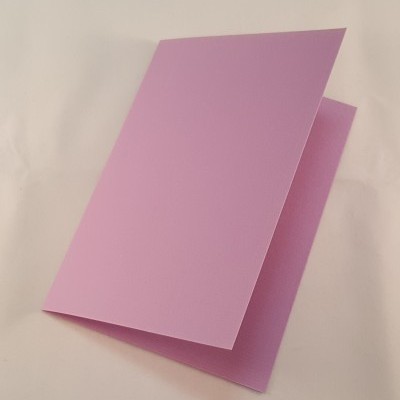 Cartão rosa claro dobrado em superfície branca