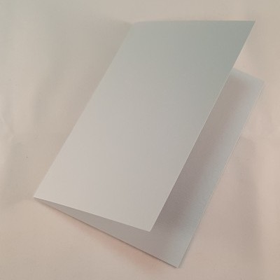 Cartão branco dobrado sobre superfície branca