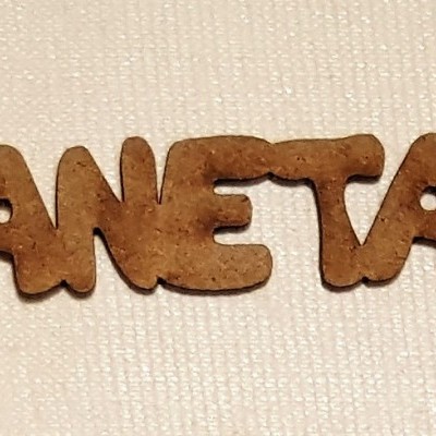 Palavra CANETAS em letras de madeira sobre tecido bege