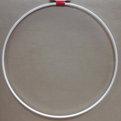 Aro circular branco com etiqueta e código de barras numa superfície bege