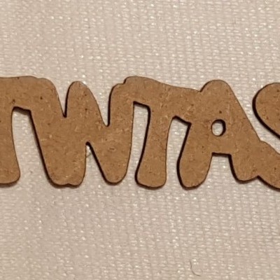 Palavra 'TWTAS' em madeira sobre tecido bege claro