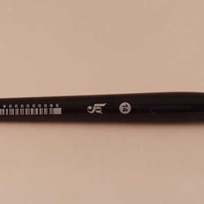 Pincel de pintura com cabo preto e cerdas laranja em fundo rosa-claro