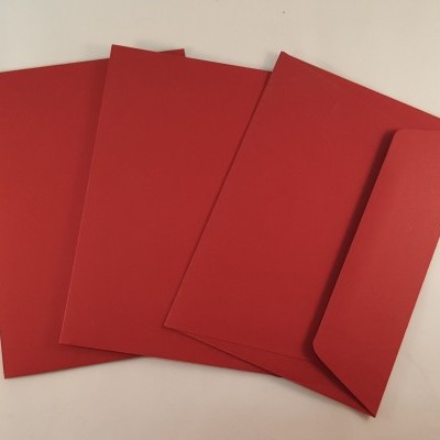 Quatro envelopes vermelhos em superfície branca.