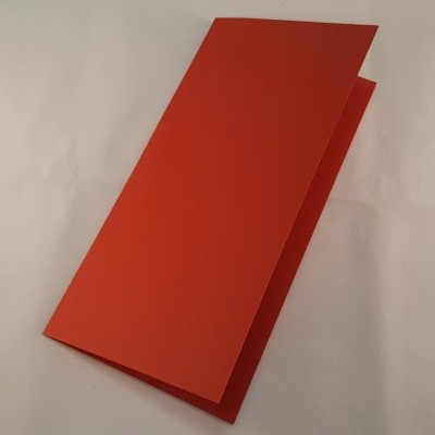 Folheto ou cartão vermelho dobrado sobre superfície branca