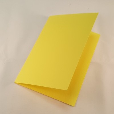 Cartão amarelo dobrado sobre superfície branca