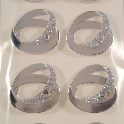 Autocolantes decorativos prateados em forma oval com brilho e cristais num suporte branco