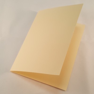 Cartão dobrável creme em papel liso sobre superfície branca