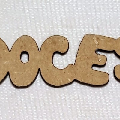 Palavra 'DOCES' em madeira sobre tecido branco