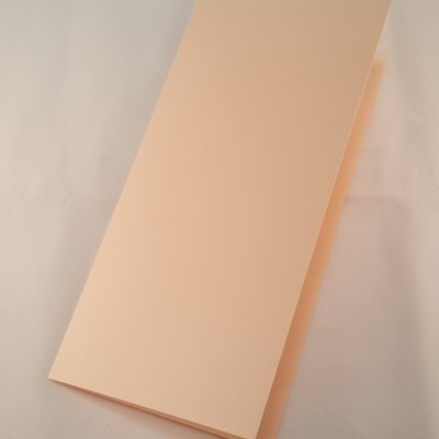 Folha de papel bege dobrada sobre superfície branca