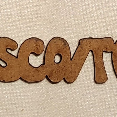 Palavra em madeira clara sobre fundo de tecido branco