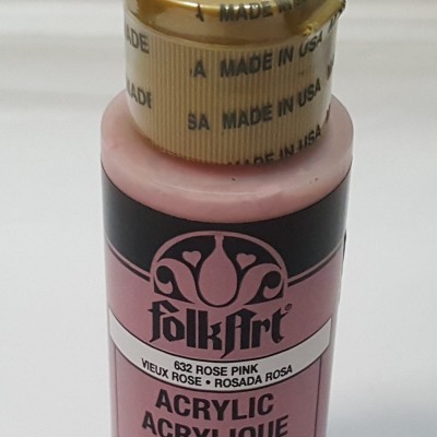 Frasco rosa de tinta acrílica com tampa dourada e texto 'FolkArt Acrylic'.
