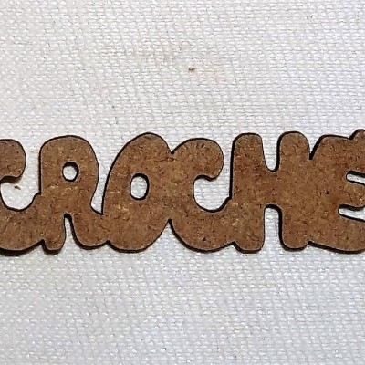 Palavra 'CROCHÊ' em letras de madeira sobre tecido branco