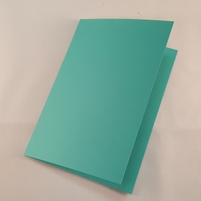 Cartão dobrado verde água sobre superfície branca