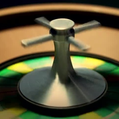 Close-up of a spinning roulette wheel with colorful numbered segments and metallic center