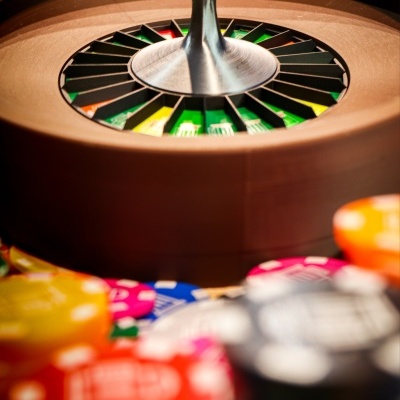 Wooden roulette wheel and colorful poker chips