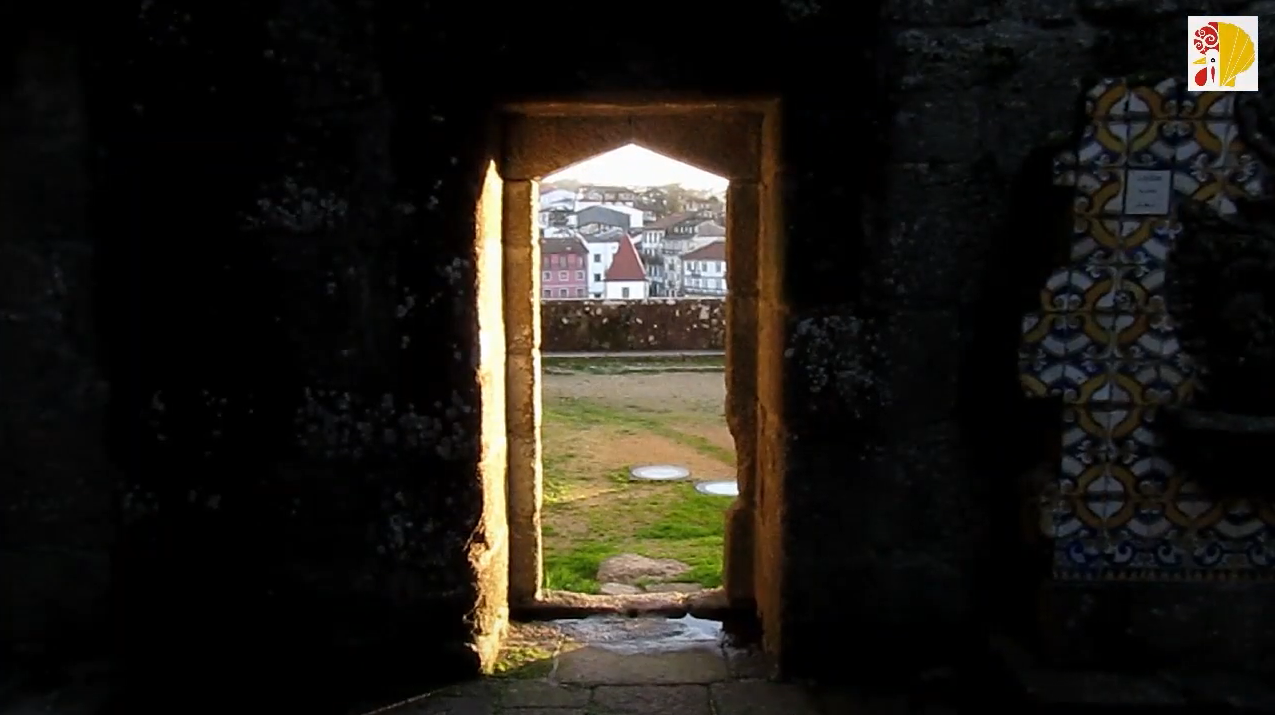 porta estreita em pedra com vista para edifícios e gramado