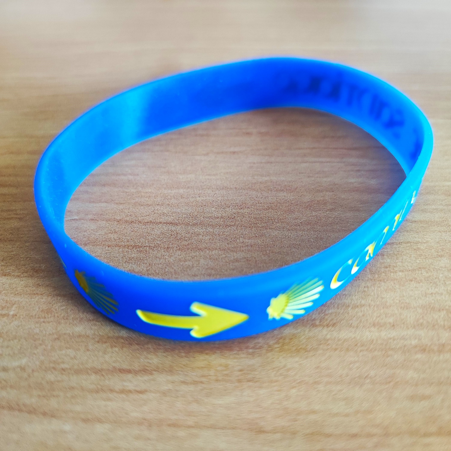 Pulseira (borracha) Pulseira azul de silicone com seta amarela e concha branca sobre madeira