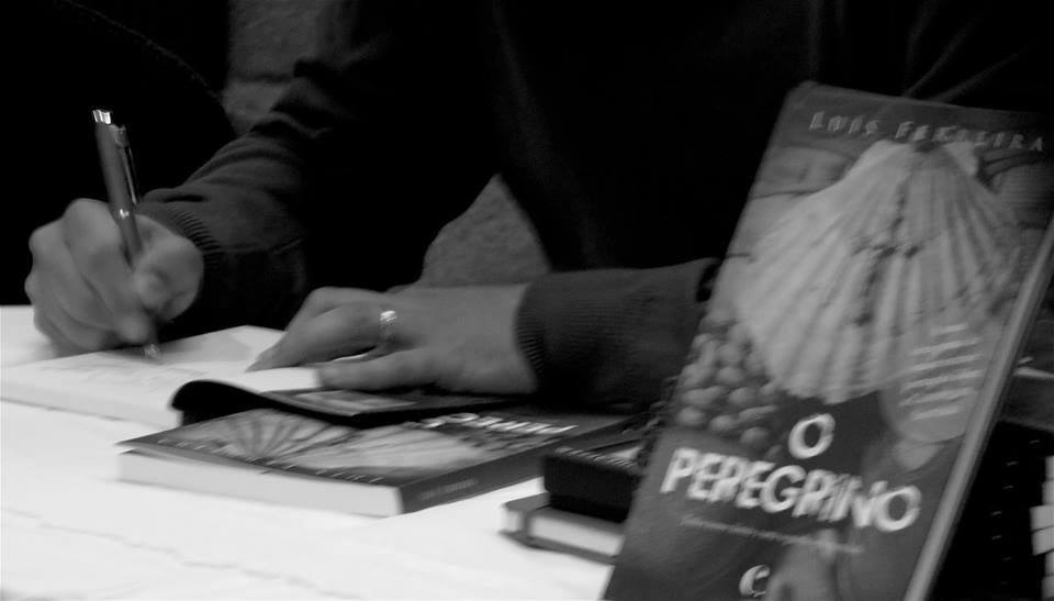 Pessoa a escrever num papel com livros, destaque para livro 'O Peregrino' com capa de concha