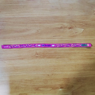 Fita rosa com texto branco sobre superfície de madeira