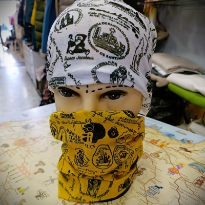 Manequim com bandana branca e tubo amarelo estampados, sobre mesa com mapa.