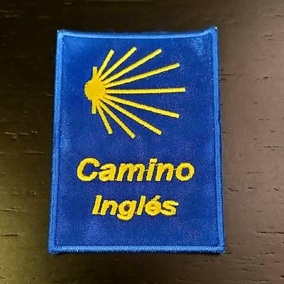 Patch azul com bordado amarelo concha e texto Camino Inglés